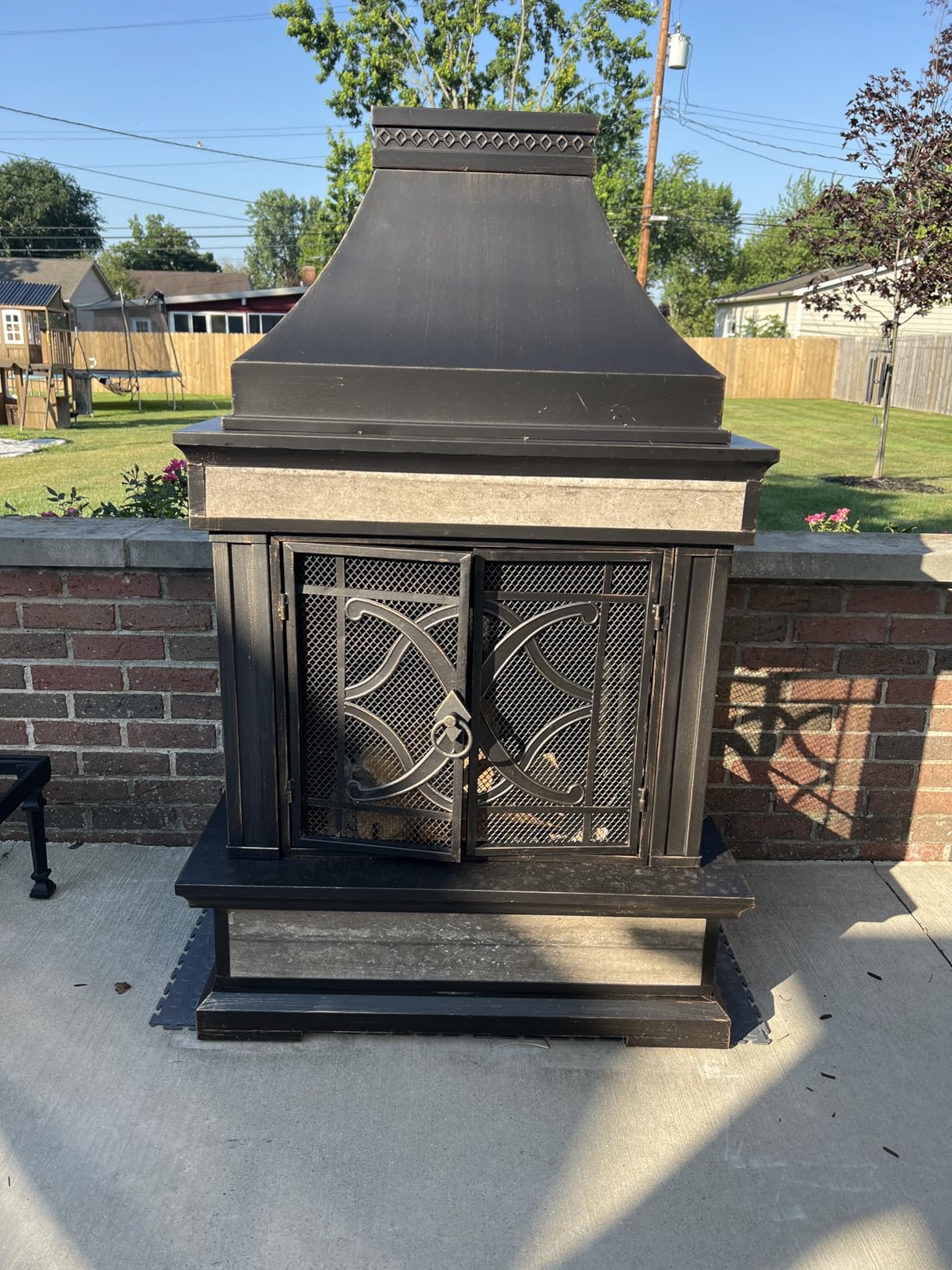 Sunjoy Outdoor Fireplace, Stone Look Tile Patio Wood Burning Steel Fireplace with Chimney, Spark Screen, Fire Poker, Rain Cover, and Removable Grate, Black with Golden Highlight customer photo 1